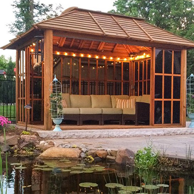A redwood gazebo with outdoor furniture and mood lights.